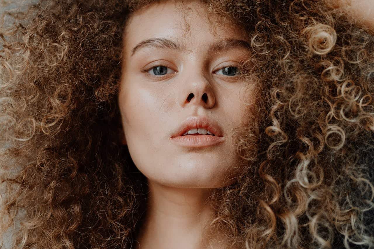 Stunning close-up portrait of a young woman with curly hair, showcasing natural beauty.