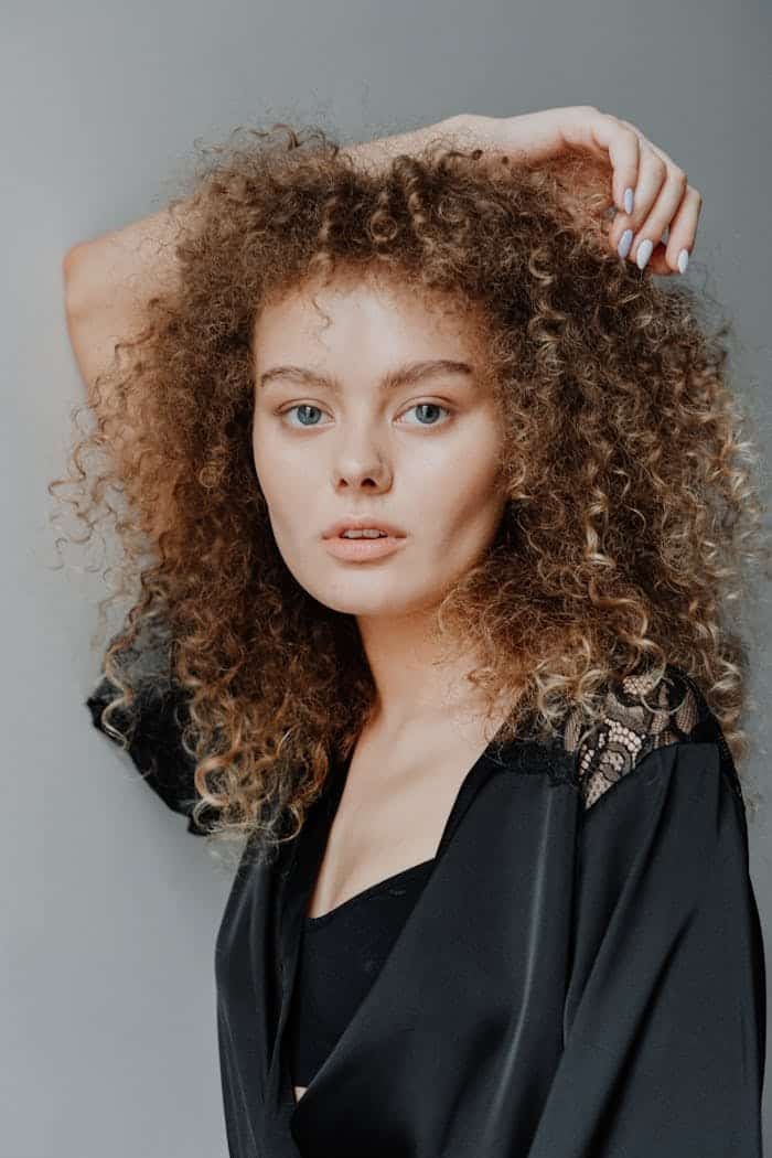 A captivating portrait of a young woman with striking curly hair and natural beauty.